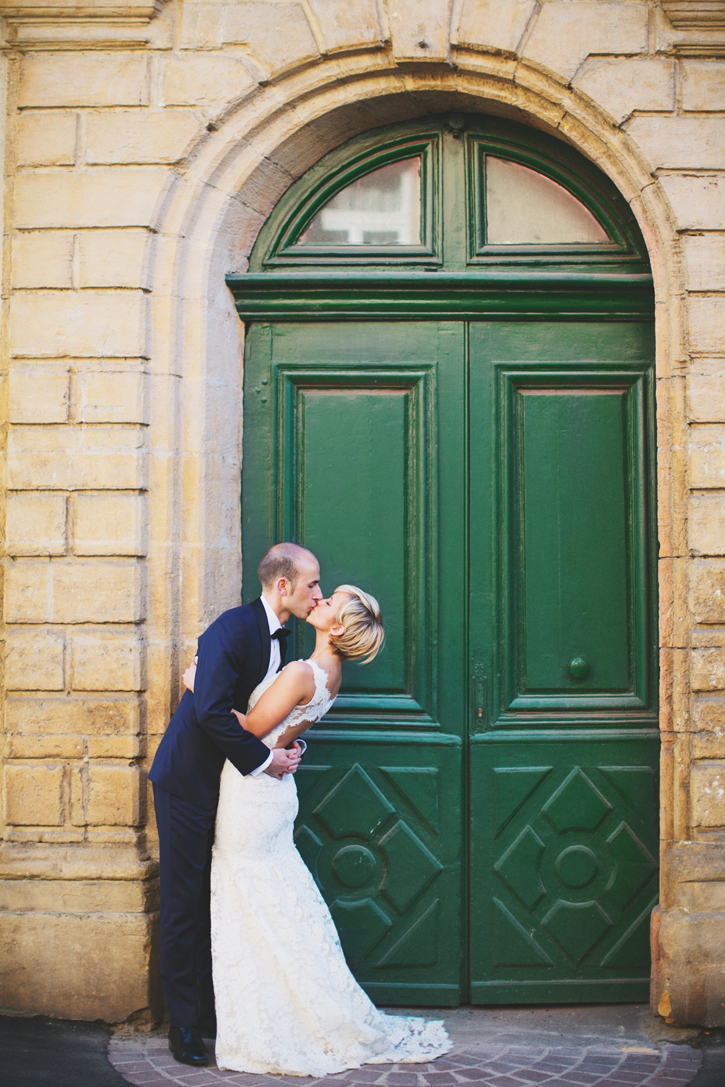 wedding couple kissing in front of green doors in Paris