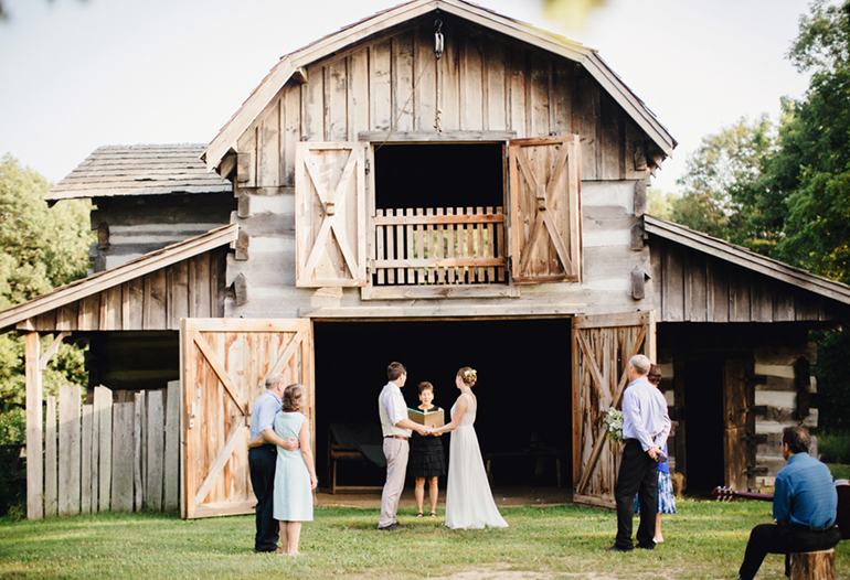wedding ceremony in front of a barn at sommer park