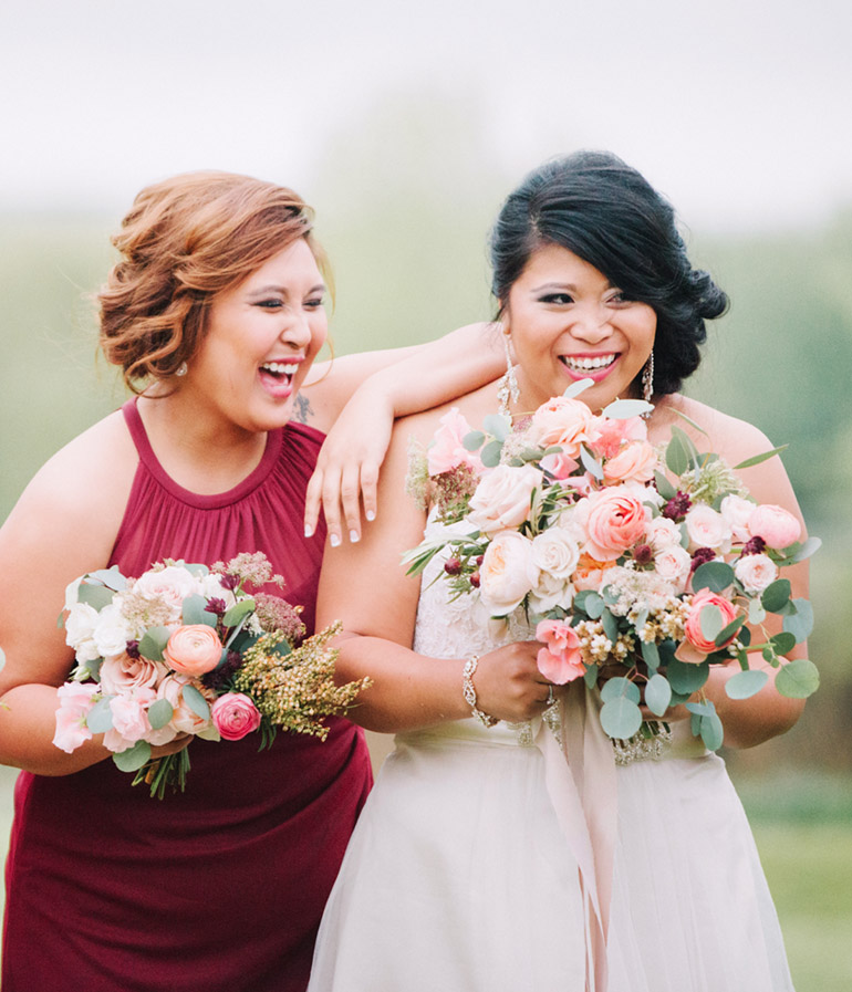 bride and made of honor laughing