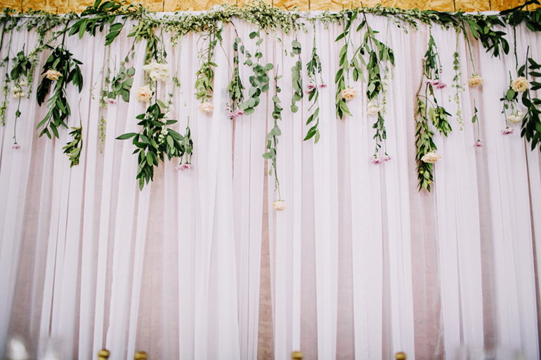 hanging floral backdrop at wedding reception