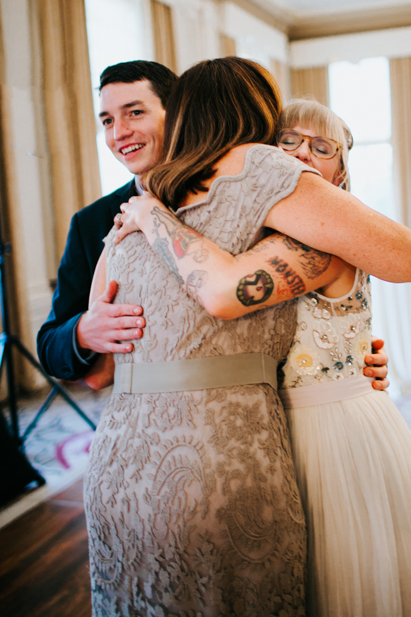 bride and groom hugging mom