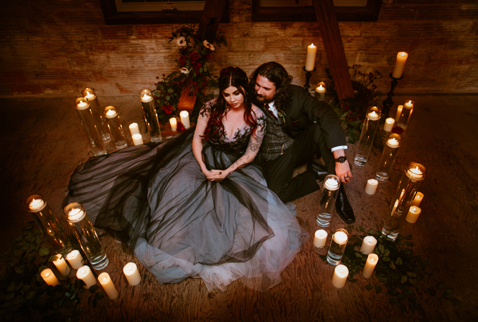 bride and groom surrounded by candles black gray wedding dress