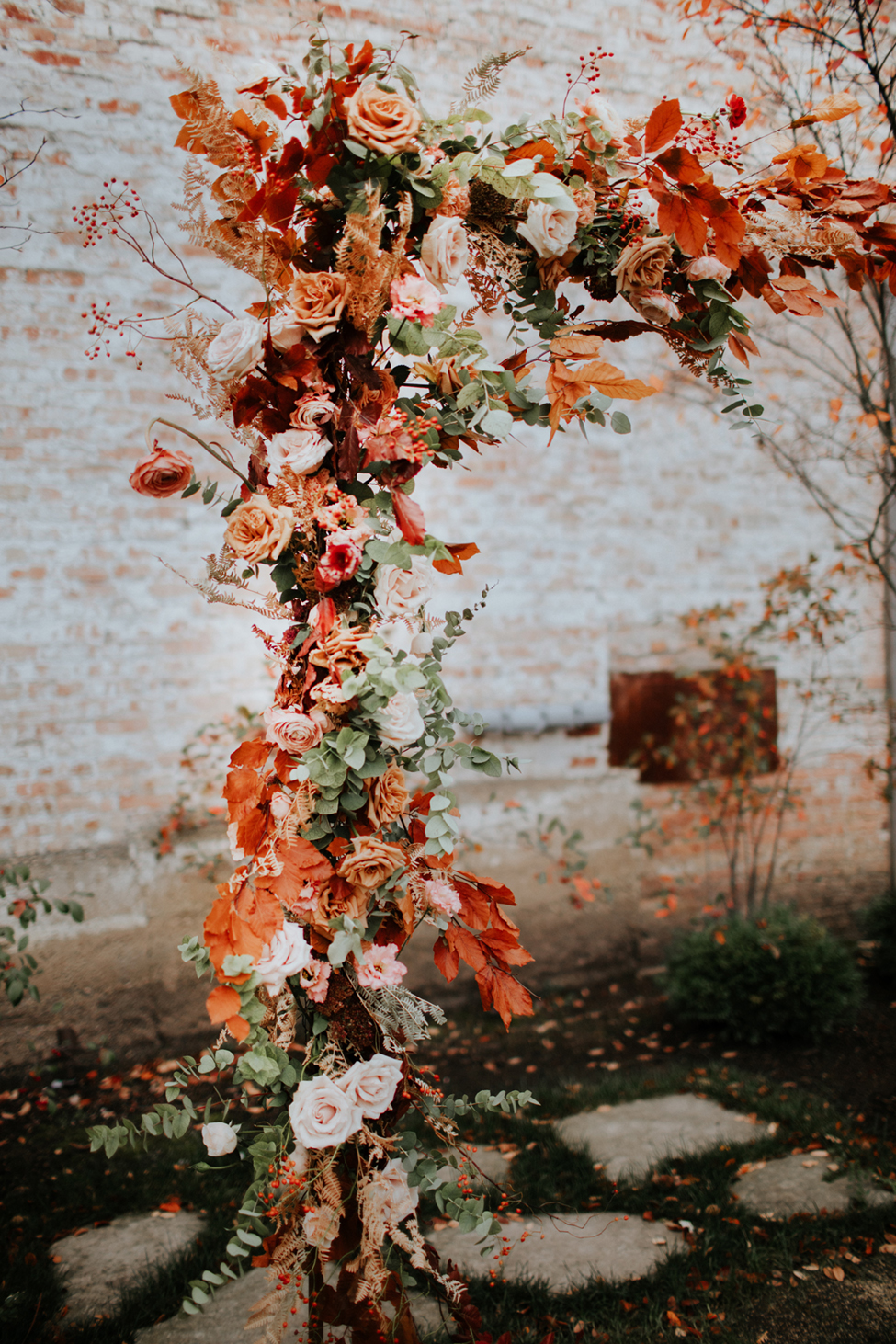 Autumn ceremony arch with peach and rust flowers by Splendor of Eden